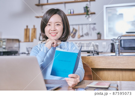 年金手帳を持つカメラ目線の若い女性 87595073