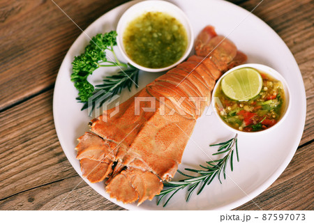 Flathead lobster shrimps served on white plate and seafood sauce, Fresh slipper lobster flathead boiled cooking with parsley rosemary in the seafood restaurant - top view 87597073