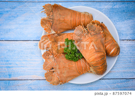 Flathead lobster shrimps served on white plate, Fresh slipper lobster flathead boiled cooking with parsley - top view 87597074