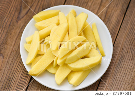 fresh raw potato wedges, chopped potatoes for cooked food on white plate fresh raw potato wedges, chopped potatoes for cooked food on white plate 87597081
