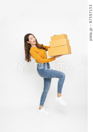 Happy Asian woman smiling and holding package parcel box isolated on white background, Delivery courier and shipping service concept, Full Length people composition 87597153