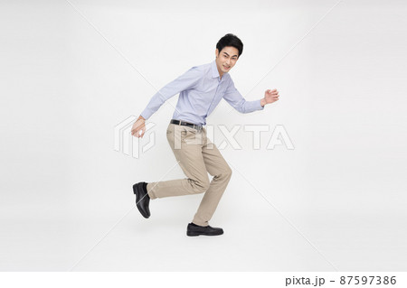 Asian cheerful businessman jumping over white background 87597386