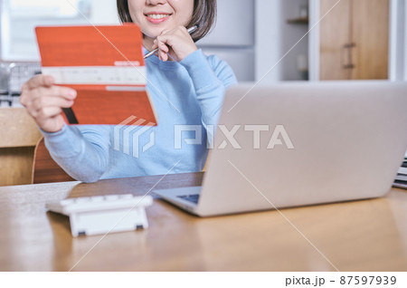 預金通帳を見つめて将来を考える若い女性 預金通帳を見つめて将来を考える若い女性 87597939