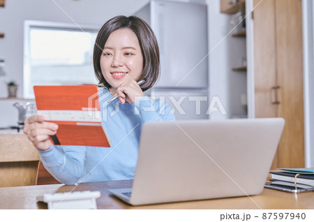 預金通帳を見つめて将来を考える若い女性 87597940