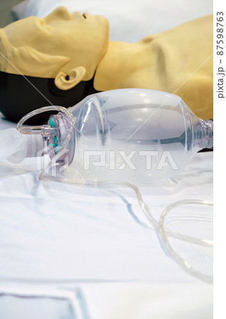 Image of CPR dummy with defibrillator  87598763