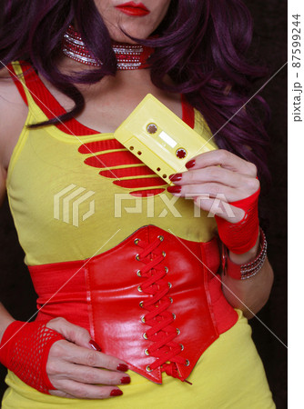 Yellow Cassette Tape With Woman in Retro clothing in background Yellow Cassette Tape With Woman in Retro clothing in background 87599244