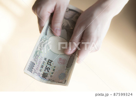 10万円を握った手 10万円を握った手 87599324