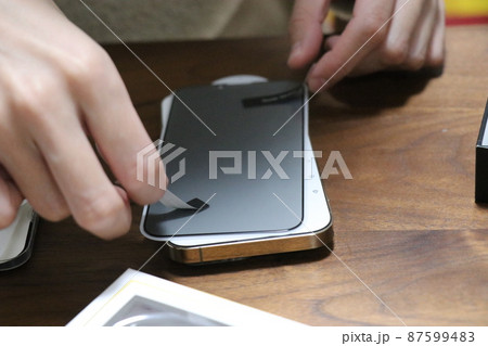 新品のスマートフォンに強化ガラスを貼る 新品のスマートフォンに強化ガラスを貼る 87599483
