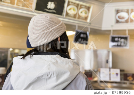 スキー場のレストハウスで食事を選ぶスノボ客女性 スキー場のレストハウスで食事を選ぶスノボ客女性 87599956