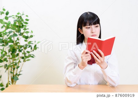 手帳を開いて見る女性 女子高校生 ピント手帳 手帳を開いて見る女性 女子高校生 ピント手帳 87600919