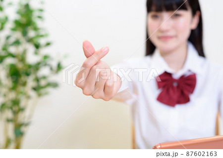 カメラににきゅんですポーズをする女子高校生 イメージ 動画視聴 オンライン授業 ビデオ通話 リモートの写真素材