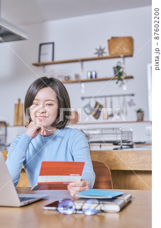 預金通帳を見つめて将来を考える若い女性 預金通帳を見つめて将来を考える若い女性 87602200