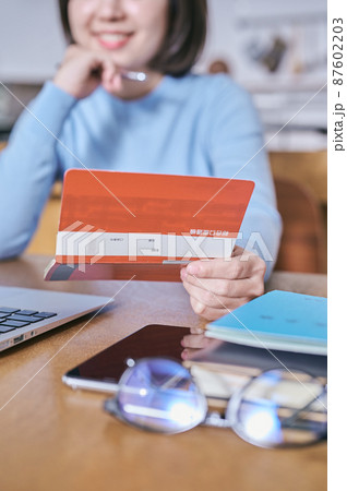 預金通帳を見つめて将来を考える若い女性 預金通帳を見つめて将来を考える若い女性 87602203