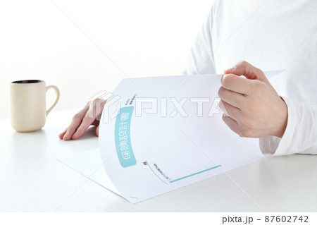 保険設計書を確認する女性の手元 保険設計書を確認する女性の手元 87602742