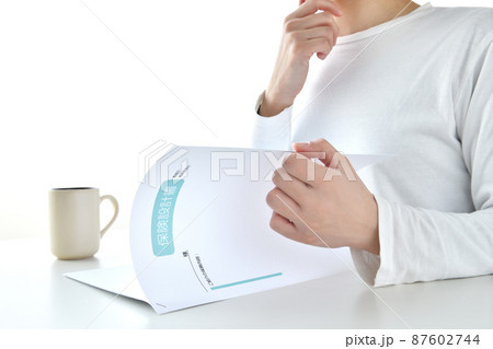保険設計書を確認する女性の手元 保険設計書を確認する女性の手元 87602744