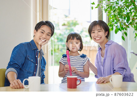リコーダーの練習をする女の子と若い夫婦 87603622