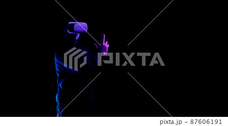Vr goggles virtual reality. Young man in digital helmet for 3d virtual reality game isolated on black neon background. Study and virtual world in 3D simulation. Vr goggles virtual reality. Young man in digital helmet for 3d virtual reality game isolated on black neon background. Study and virtual world in 3D simulation. 87606191