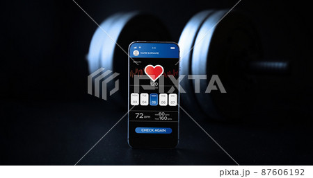 Health app. Smart phone screen with fitness health or sport gym mobile application on black dumbbell background. Home online workout. 87606192