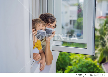 Extremly tired father and son looking out the window, home alone. self-isolation at home, quarantine due to pandemic COVID 19. Mental health problems in self-isolation at home, quarantine, isolation Extremly tired father and son looking out the window, home alone. self-isolation at home, quarantine due to pandemic COVID 19. Mental health problems in self-isolation at home, quarantine, isolation 87606545