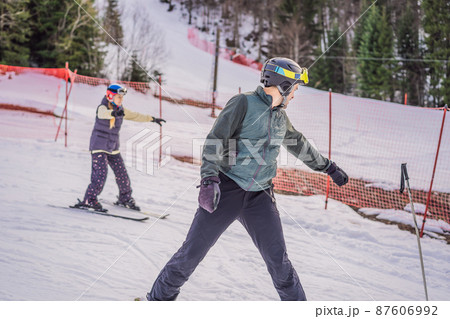Woman learning to ski with instructor. Winter sport. Ski lesson in alpine school Woman learning to ski with instructor. Winter sport. Ski lesson in alpine school 87606992