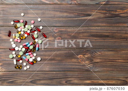 Protective face masks or surgical masks, medicine pills and thermometer on table background. Coronavirus disease. Corona virus concept. Space for text Protective face masks or surgical masks, medicine pills and thermometer on table background. Coronavirus disease. Corona virus concept. Space for text 87607030
