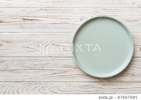 Top view of empty blue plate on wooden background. Empty space for your design 87607085