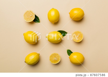 Many fresh ripe lemons as colored background, top view. Elegant background of lemon and lemon slices Top view flat lay Many fresh ripe lemons as colored background, top view. Elegant background of lemon and lemon slices Top view flat lay 87607586