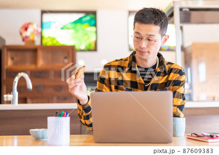 3時のおやつタイムでお菓子を手にする男性起業家 87609383