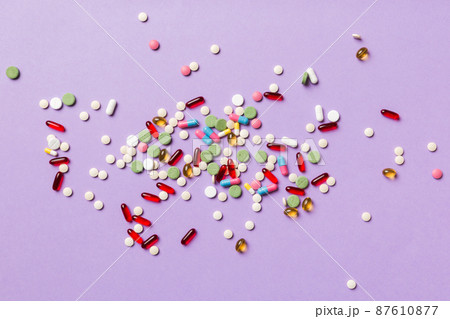 assorted pills and tablets top border over colored background. Many different pills and space for text on colorful background, top view assorted pills and tablets top border over colored background. Many different pills and space for text on colorful background, top view 87610877