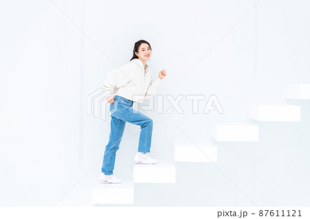 階段をあがる若い女性 87611121