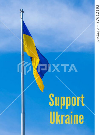 SUPPORT UKRAINE text on Ukrainian national flag flutters in the wind against the blue sky. National symbol of ukrainian people - blue and yellow. No war. War Protest against Russian invasion of SUPPORT UKRAINE text on Ukrainian national flag flutters in the wind against the blue sky. National symbol of ukrainian people - blue and yellow. No war. War Protest against Russian invasion of 87612192