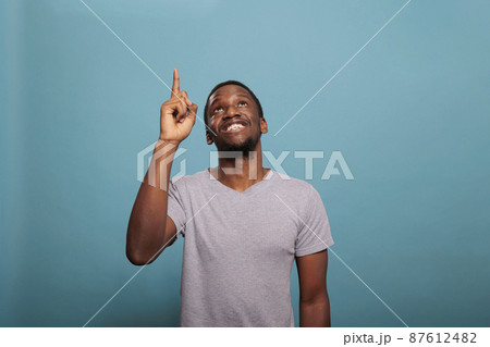 Portrait of african american man pointing up with index finger 87612482