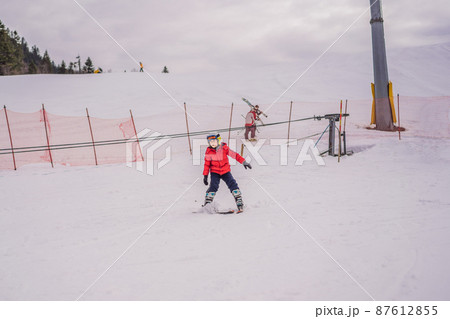 Child skiing in mountains. Active toddler kid with safety helmet, goggles and poles. Ski race for young children. Winter sport for family. Kids ski lesson in alpine school. Little skier racing in snow Child skiing in mountains. Active toddler kid with safety helmet, goggles and poles. Ski race for young children. Winter sport for family. Kids ski lesson in alpine school. Little skier racing in snow 87612855