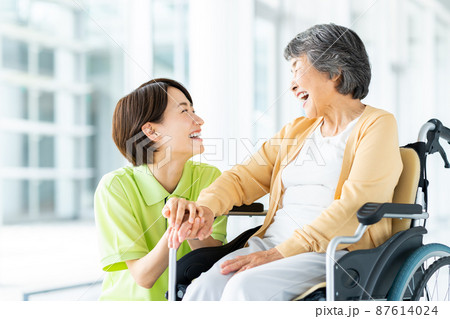 車椅子のシニアの女性とミドルの介護福祉士 車椅子のシニアの女性とミドルの介護福祉士 87614024