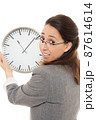 Young woman holding a clock. 87614614