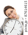 Young woman holding a clock. 87614615