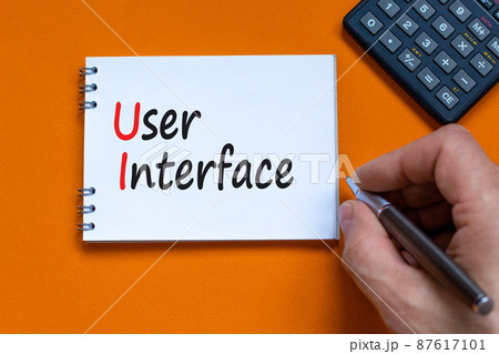 UI user interface symbol. Concept words UI user interface on white note. Businessman hand, calculator. Beautiful orange background. Copy space. Business and UI user interface concept. 87617101