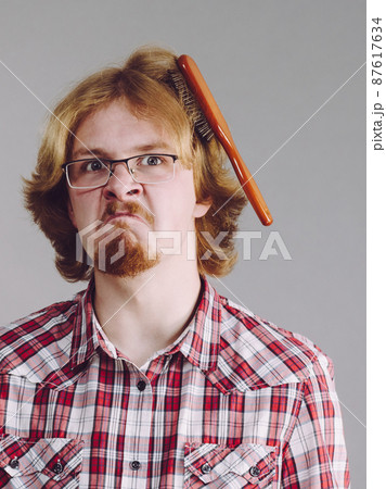 Man having problem with brushing hair 87617634