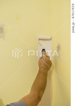 Hand applying paint on wall Hand applying paint on wall 87617659