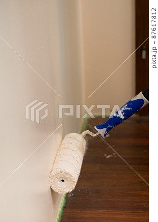 Person applying paint on wall 87617812