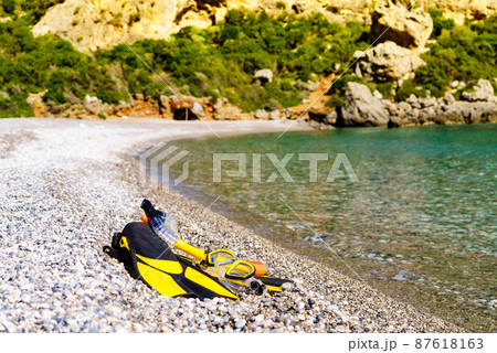 Flippers and snorkeling tube on sea shore Flippers and snorkeling tube on sea shore 87618163