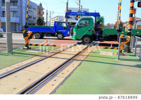 踏み切りを渡る青と緑のトラック 87618899