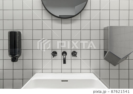 Modern contemporary public restroom minimal interior with metro style white tiles, round mirrors Modern contemporary public restroom minimal interior with metro style white tiles, round mirrors 87621541