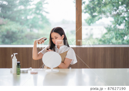 整髪料をつける女性(悩む) 整髪料をつける女性(悩む) 87627190