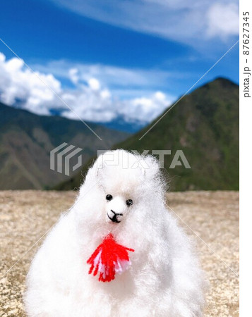 【ペルー】マチュピチュ遺跡:美しい山並みと青空を背景に記念撮影をする白いアルパカ人形 【ペルー】マチュピチュ遺跡:美しい山並みと青空を背景に記念撮影をする白いアルパカ人形 87627345