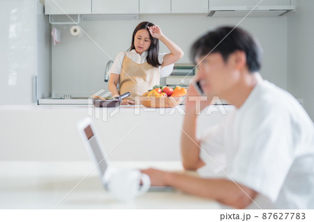 出産直前の妊婦と仕事する男性(体調不良) 出産直前の妊婦と仕事する男性(体調不良) 87627783