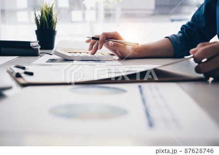 Close up Business woman hand using calculator to calculate the company's financial results and budget. Account Audit Concept. Close up Business woman hand using calculator to calculate the company's financial results and budget. Account Audit Concept. 87628746