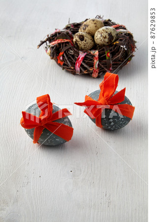 Painted chicken eggs tied with a red ribbon against the background 87629853