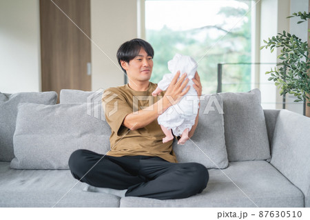 赤ちゃんの面倒を見る男性（笑顔） 87630510