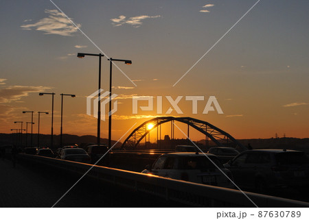 多摩川に架かる多摩河原橋から見た夕日 87630789